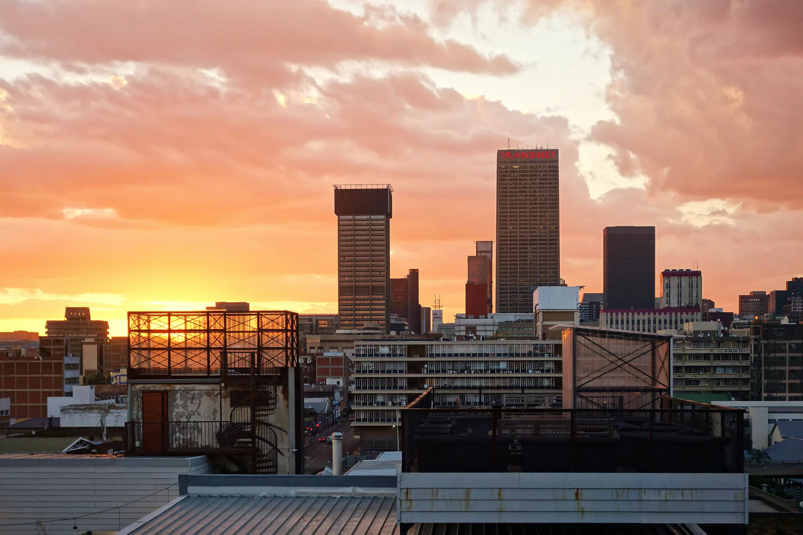 Johannesburg city centre at dawn under an orange sky, Carlton Centre on the skyline